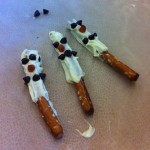 We used melted white chocolate on a pretzel stick with mini chocolate chips and we also added a marshmallow for the hat and the Kids Cliff Twisted Fruit for the scarf!